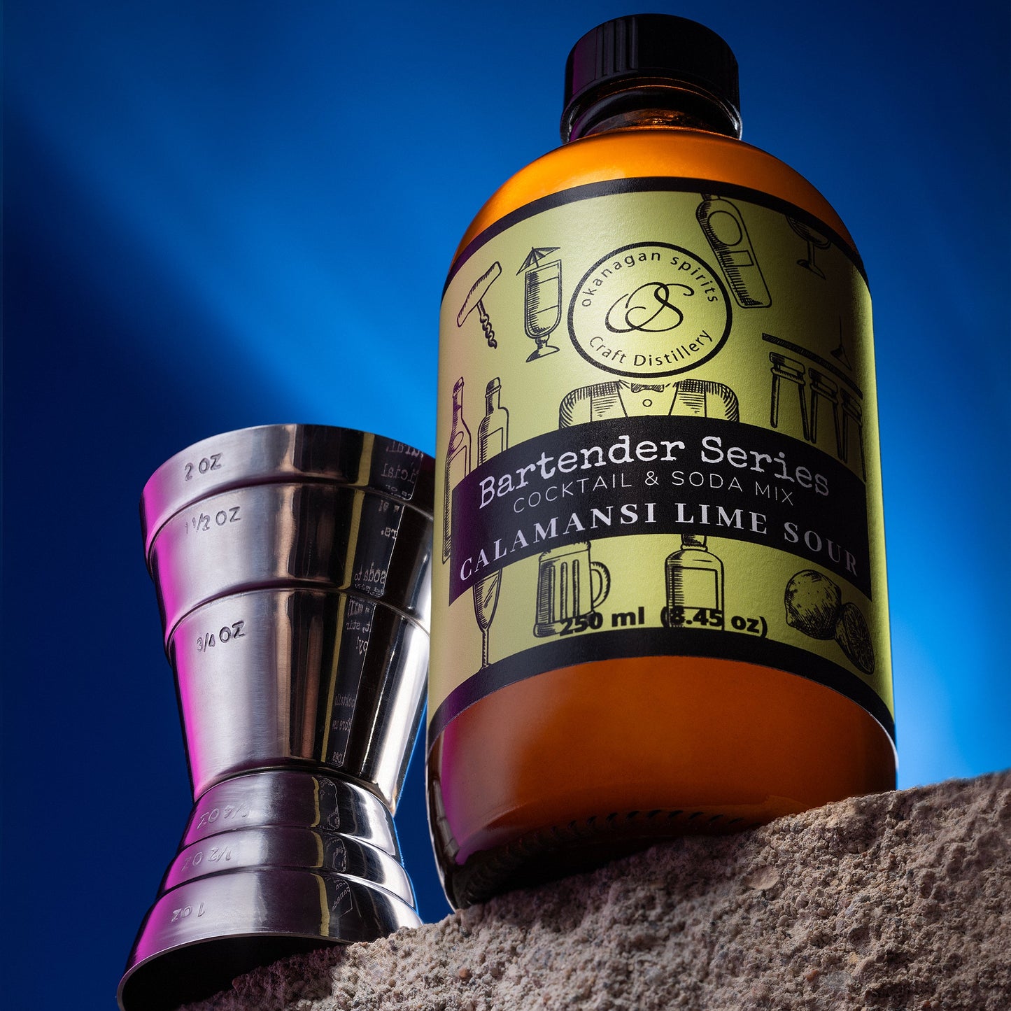Bottle of Calamansi Lime Sour with a cocktail shaker against a blue sky