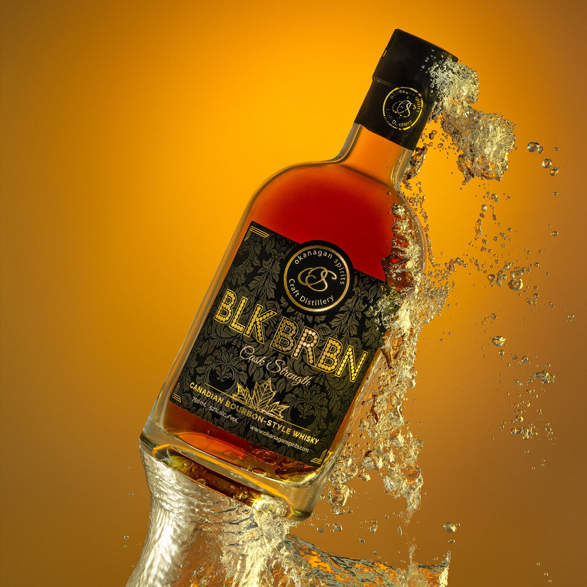A bottle of Blk Brkn Bourbon-Style Canadian Whisky is shown tilted with a dramatic splash of clear liquid and water around it against a warm orange gradient background.