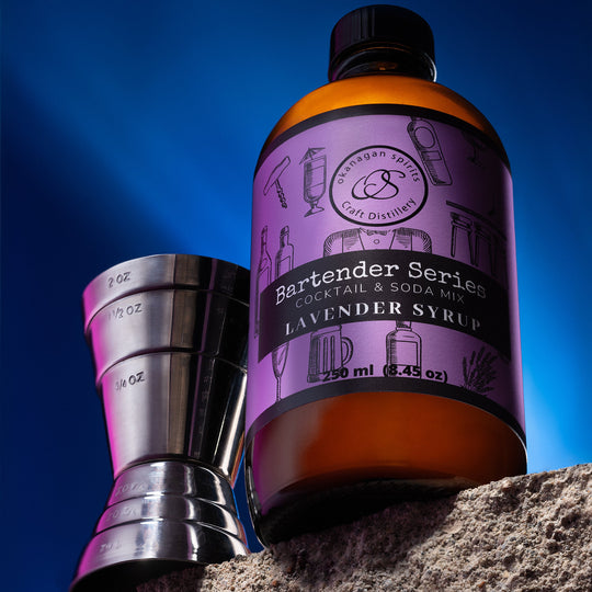Bottle of Lavender Syrup with a cocktail shaker against a blue sky