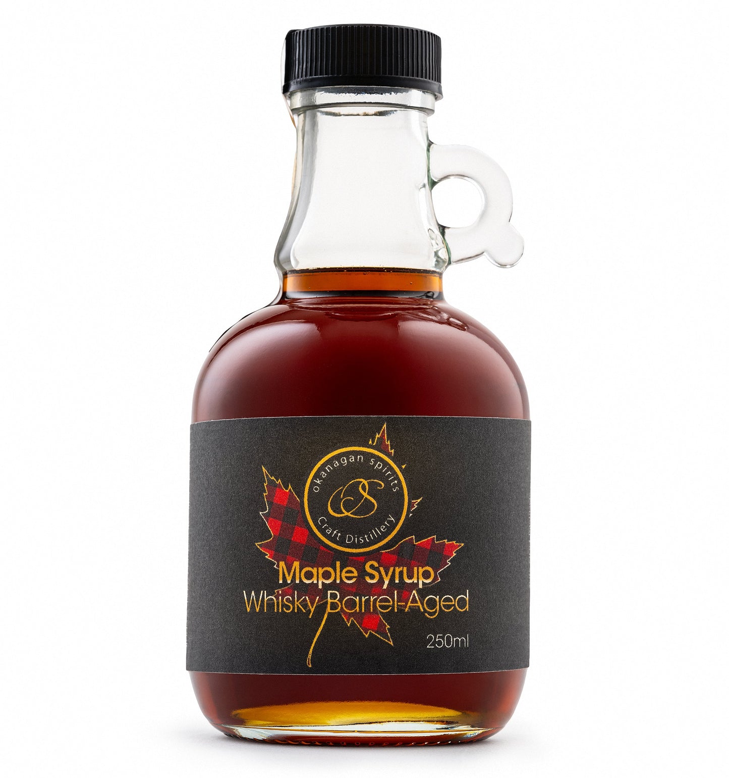 A 250ml bottle of Barrel Aged maple syrup by Okanagan Spirits, featuring amber liquid in a clear glass bottle with a black cap and a black label with red maple leaf graphics.