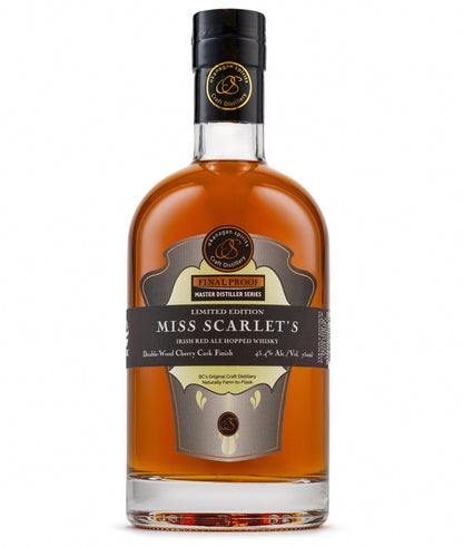 A bottle of Miss Scarlet's Limited Edition Hopped Canadian Whisky, showing the amber liquid inside a clear glass bottle with a black cap and detailed label.